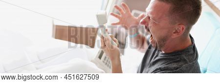 An Angry Man Sits On The Bed And Shouts Into The Phone, Close-up. Dissatisfaction With The Hotel Ser