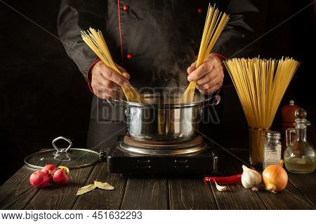 A Professional Chef Prepares Spaghetti Soup In A Pot In The Kitchen. The Idea For A Hotel To Prepare