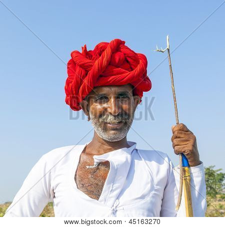 Ein Rajasthani-Tribal-Mann, die mit traditionellen bunten Turban und liebt es, Pose