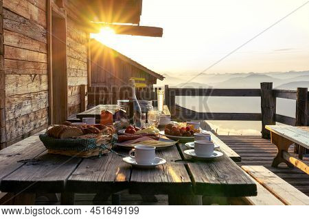 Breakfast Table In Rustic Wooden Terace Patio Of A Hut Hutte In Tirol Alm At Sunrise
