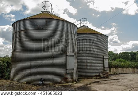 Two Silos Used For Storing Grain And Feed On A Farm In Basingstoke, Hampshire On A Sunny Summer Day.