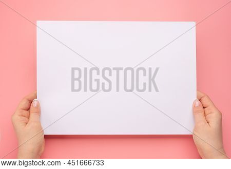 Female Hands Holding Blank Paper Isolated On Pink Background. Woman Hands With Mockup Empty Paper Sh