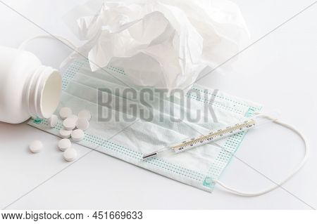 Close Up Of Thermometer, Face Mask And White Pills