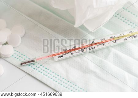 Close Up Of Thermometer, Face Mask And White Pills