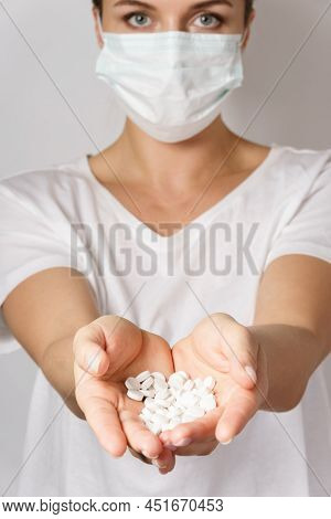 Woman Wearing Face Mask Is Holding A White Pills