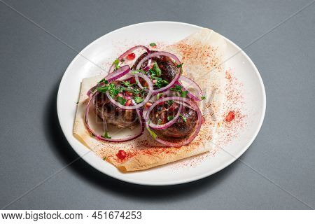 Georgian Fried Pork Sausages Kupaty With Onion, Cilantro On Pita On White Plate