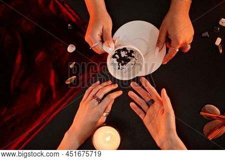 Top Down View At Female Fortune Teller Reading Coffee Telling Destiny In Seance With Young Woman, Co