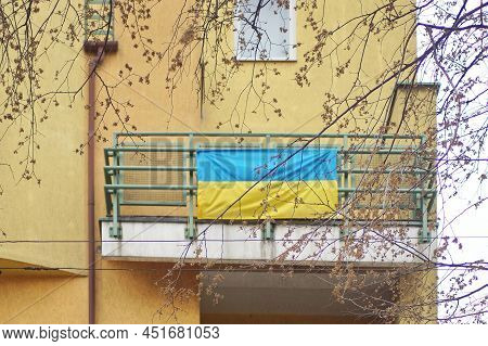 The Flag Of Ukraine Hangs On The Balcony. The People Hang Out Flags As A Confirmation Of The Desire 