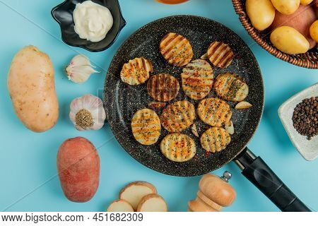 Top View Of Fried Potato Slices In Frying Pan With Uncooked Ones In Basket Mayonnaise Garlic Salt Bl