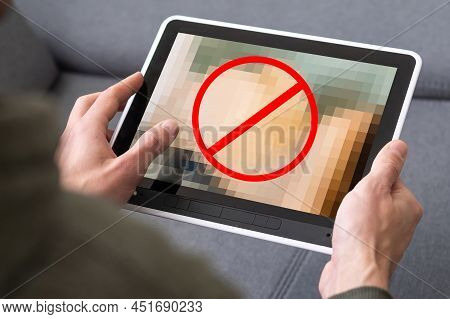 Closeup Of A Young Caucasian Man Watching A Nude Woman In His Tablet Computer