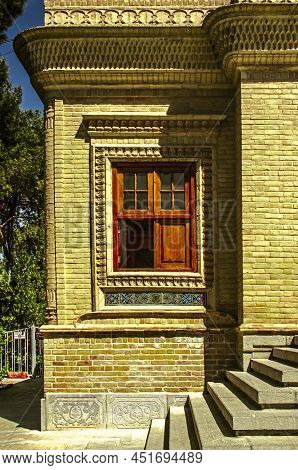 Yazd, Iran, February 19, 2021: A Four-leaf Window With A Protruding Cornice Framed By Patterned Stuc
