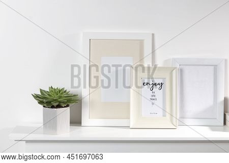 Echeveria In A Geometric Vase, Photo Frames On A Chest Of Drawers Against A White Wall. Scandinavian