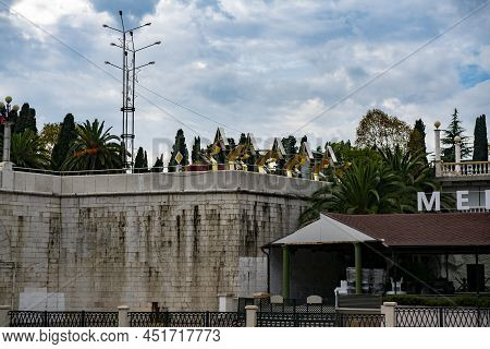 A Stone Wall Near The River Bank With Golden Stars Against A Cloudy Sky.