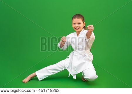 An Athlete In A White Kimono Stands In A Fighting Pose. The Concept Of Karate, Mixed Martial Arts.