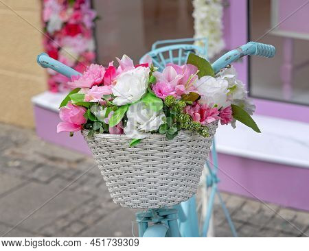 Plastic Flowers Decor In Front Basket At Old Bicycle