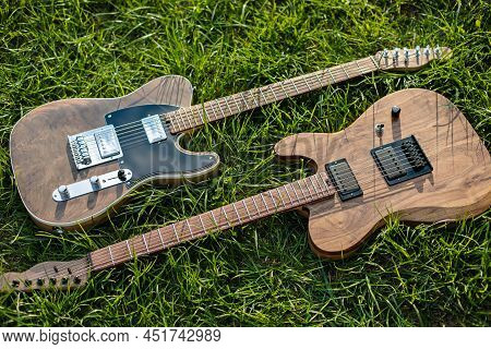 Electric Guitars Lying On Green Fresh Grass In Sunlight