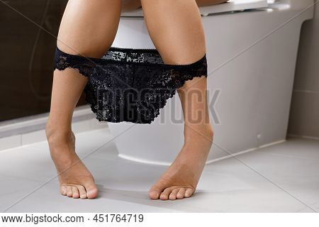 Woman Is Sitting On The Toilet With Panties Pulled Part Way Down