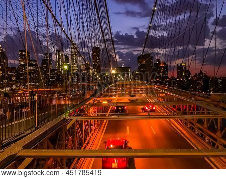 Tourist Walking And Enjoying The Twilight Skyline Over New York City In Background From The Brooklyn