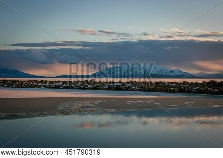Ice-covered Lake At Sunset And Mountain In The Distance