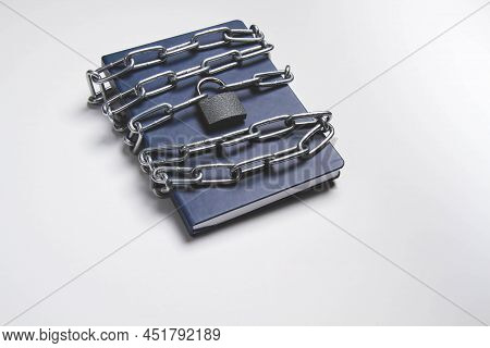 The Book Is Locked Under Lock And Key On A White Background. Secret Archive. Chain On The Book Close