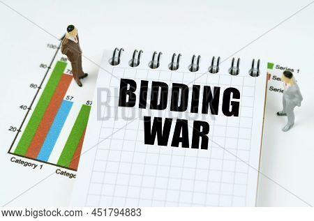 Business And Finance Concept. On The Chart There Are Miniature Figures Of Businessmen And A Notepad 