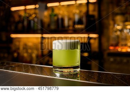 Beautiful View Of Glass With Green Foamy Cocktail On Bar Counter