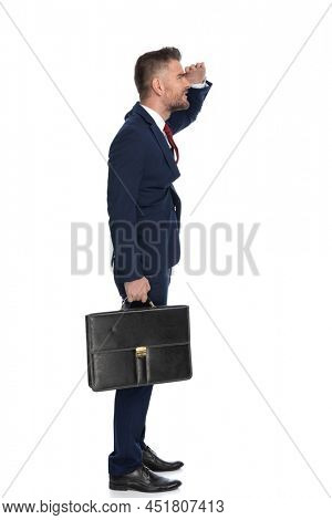 side view of a handsome businessman protecting his eyes from the sunlight to see beter what's in front of him