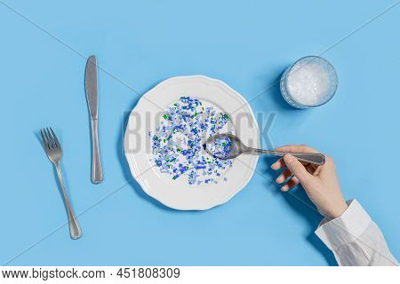 Plate With Plastic Pieces Instead Of Food And Glass Of Microplastics Instead Of Water. Microplastic 