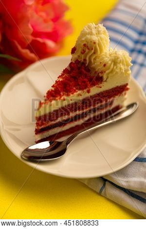 plate of delicious red velvet cake on top of kitchen towel and next to flowers in a beauitiful styling