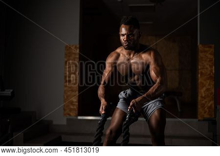 Attractive African American Man With Naked Torso Doing Endurance Exercises With Trope.