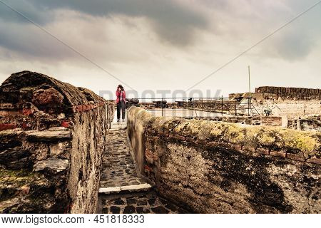Tourist Woman With Camera Taking Travel Picture On Sohail Castle In Fuengirola, Malaga Spain. Touris