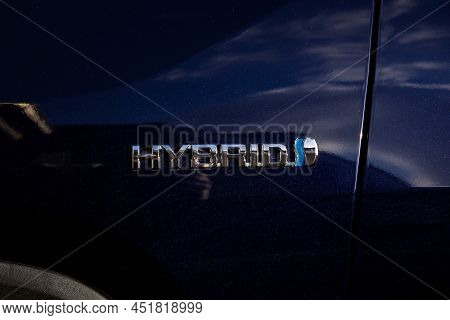 Brecht, Belgium - Februari 5 2022: A Hybrid Logo On A Blue Verhicle Body Showing That The Car Has Hy