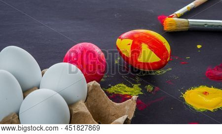 Easter eggs painting set up on black background with sopy space
