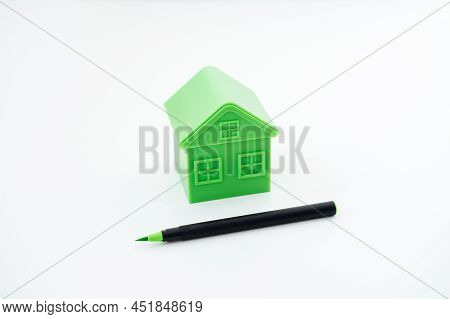 Greenwashing Concept With Green And Black Pen And Plastic House. Greenwashing Marketing Ploy Product