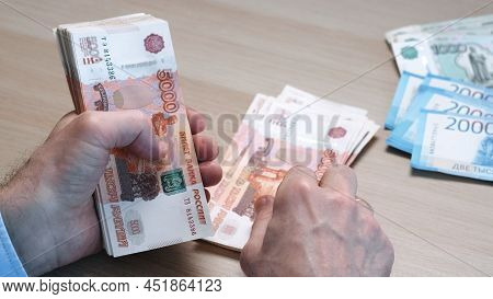 Close-up Of Hands Counting Five-thousandth Banknotes Of The Russian Ruble. Mens Hands Count Russian 