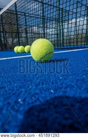 Selective Approach, Paddle Tennis Balls In Front Of The Net Of A Blue Paddle Tennis Court