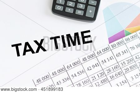 Tax Time Inscription On The Notebook Next To The Calculator, Accounting Items And Financial Charts