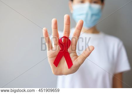 Hand Holding Red Ribbon For December World Aids Day (acquired Immune Deficiency Syndrome), Multiple 
