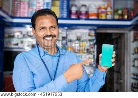 Smiling Medical Shop Owner Showing Green Screen Mobile Phone By Looking At Camera - Concept Of Ephar