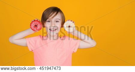 Happy Cute Boy Played With Donuts On Yellow Background Wall. Kid Enjoying Sweets. Birthday Party. Ta