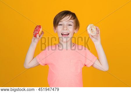 Happy Cute Boy Played With Donuts On Yellow Background Wall. Kid Enjoying Sweets. Birthday Party. Ta