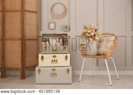 Wicker Chair With Dry Flowers And Storage Trunks Indoors. Interior Design