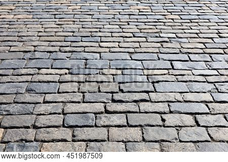 Stone Pavement Texture, Cobbled Street In Sunlight. Old Paved Road With Tiles From Cobblestones