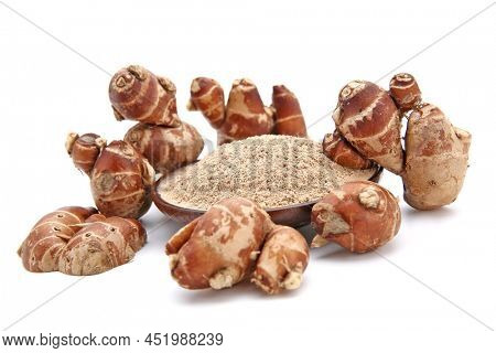 Fresh kencur roots and ground kencur powder on white background