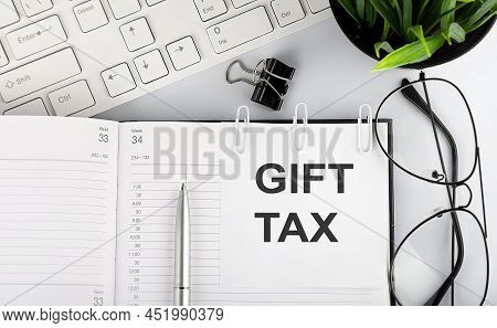 Text Gift Tax On A White Stickers On The Notebook With Keyboard And Glasses.