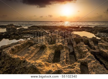Sunset Over The Sea And Rocky Coast With Ancient Ruins