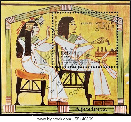 A stamp printed in Sahara OCC. R.A.S.D shows ancient Egyptians playing chess