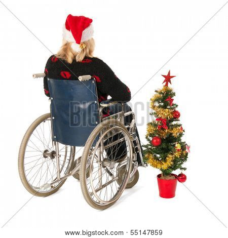 Blond woman in wheelchair with Christmas tree isolated over white background