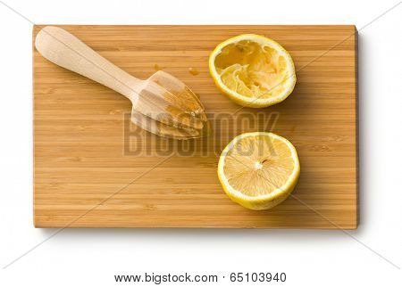 squeezed lemon fruit and citrus reamer on cutboard