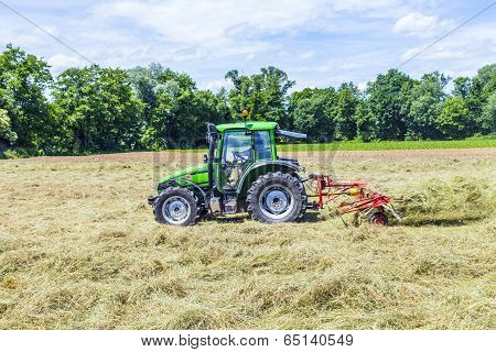 Tractor In Meadow Making Hay